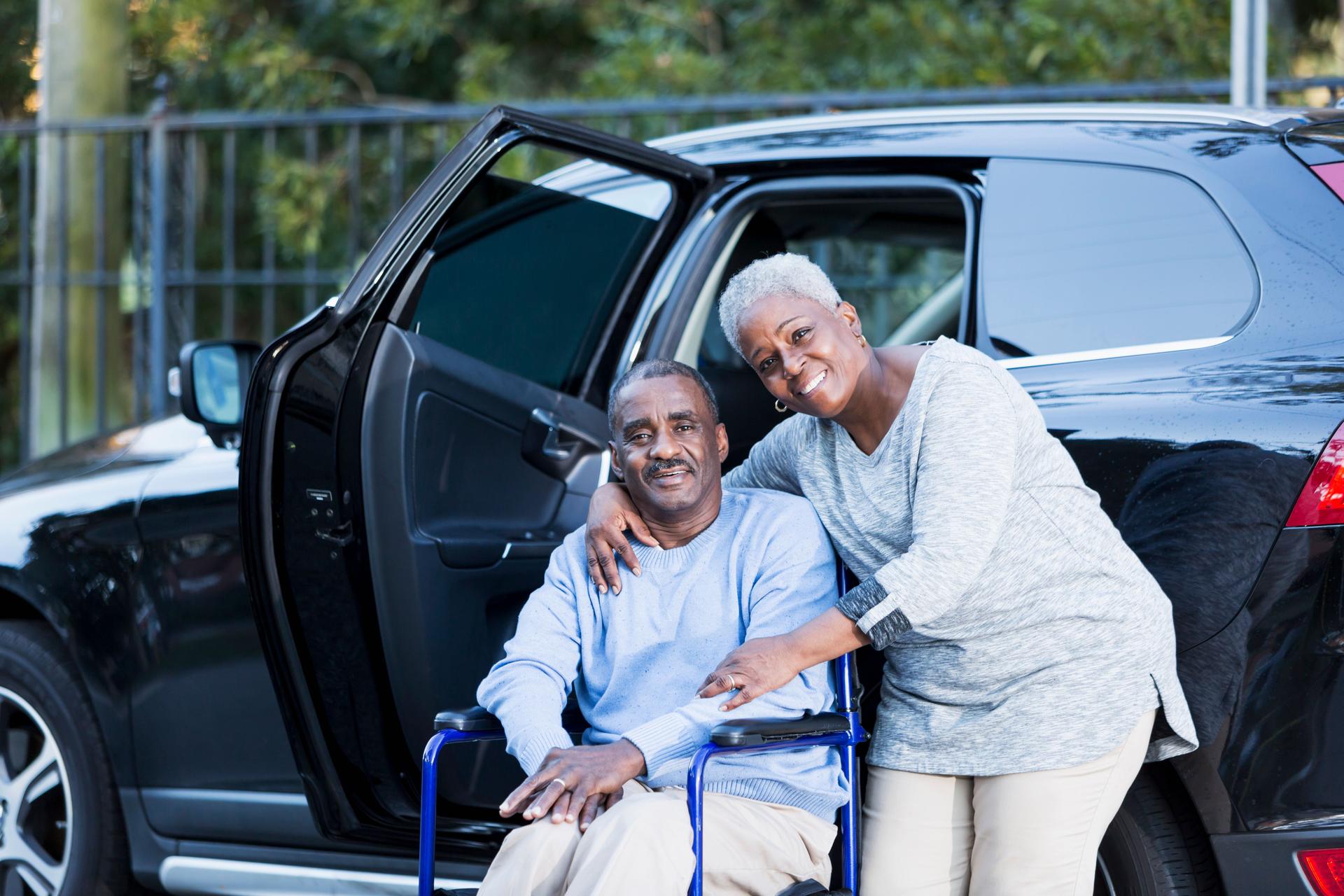 Disabled senior man in wheelchair with his devoted wife